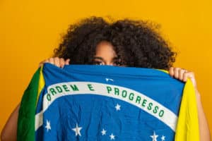 fa de mulher negra misteriosa segurando uma bandeira do brasil na sua cara cores do brasil na parede verde azul e amarelo eleicoes futebol ou politica 63135 1133