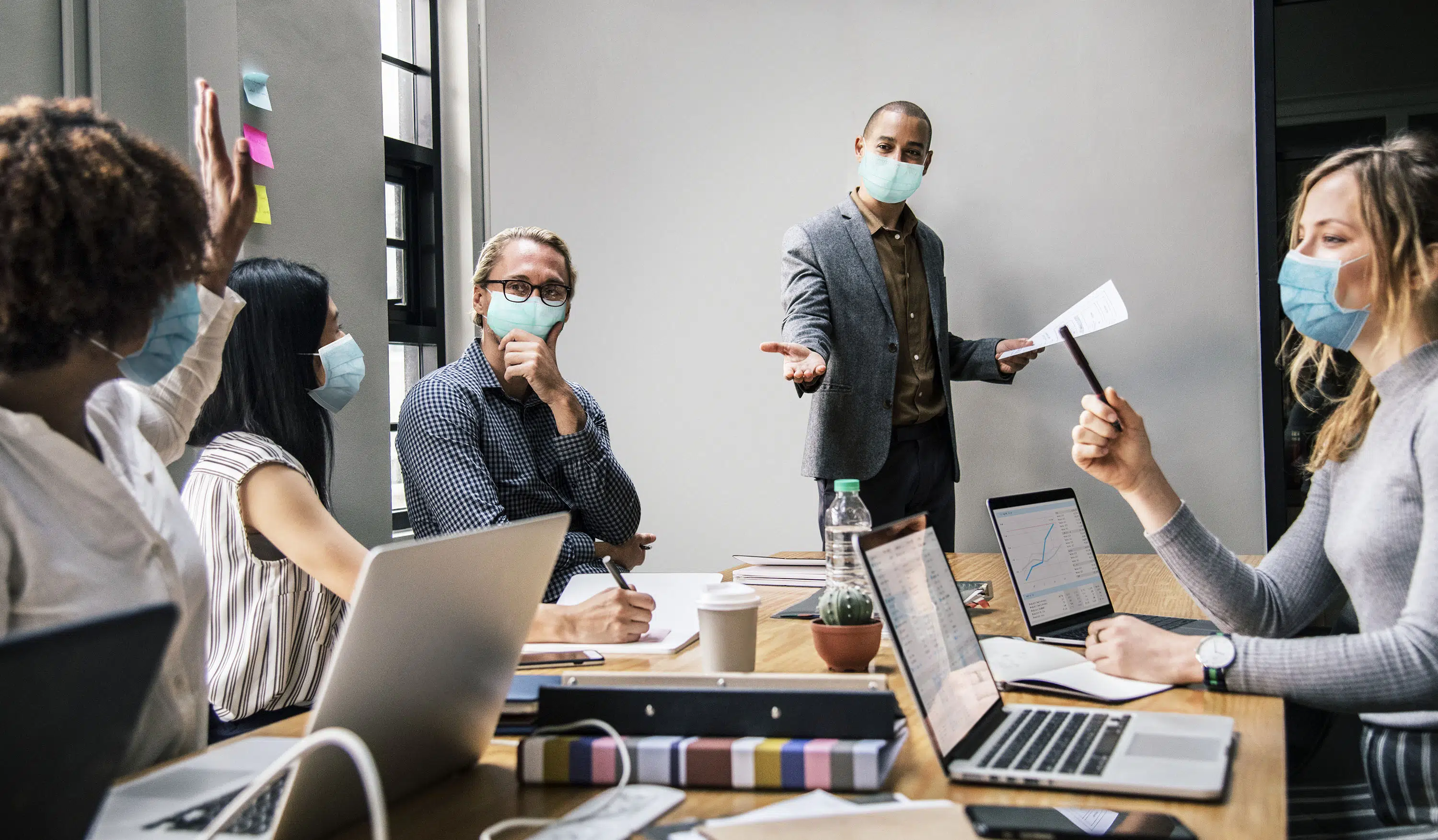 business people wearing masks in coronavirus meeting the new normal scaled