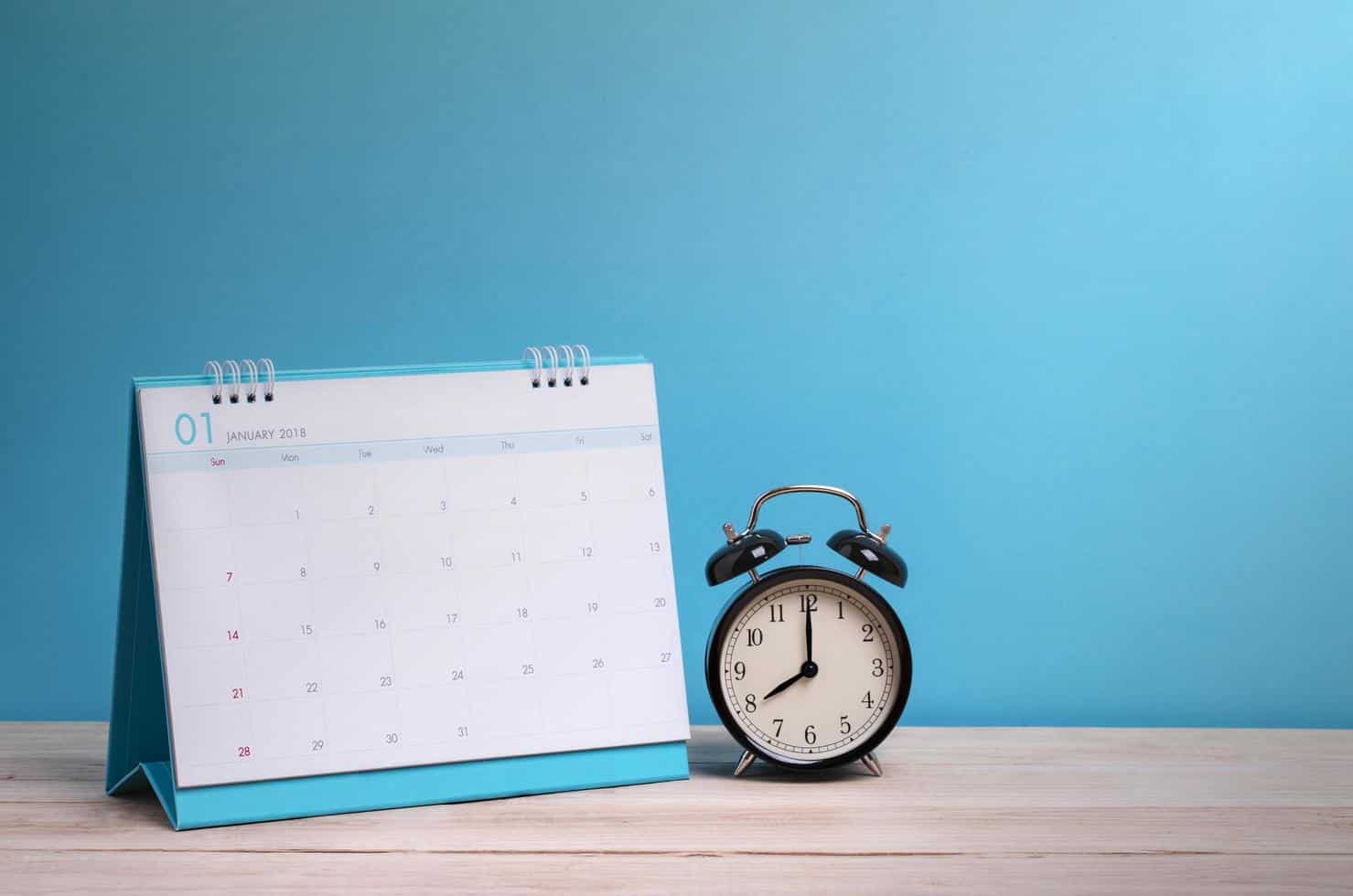1920212 relogio e calendario na mesa com fundo azul gratis foto