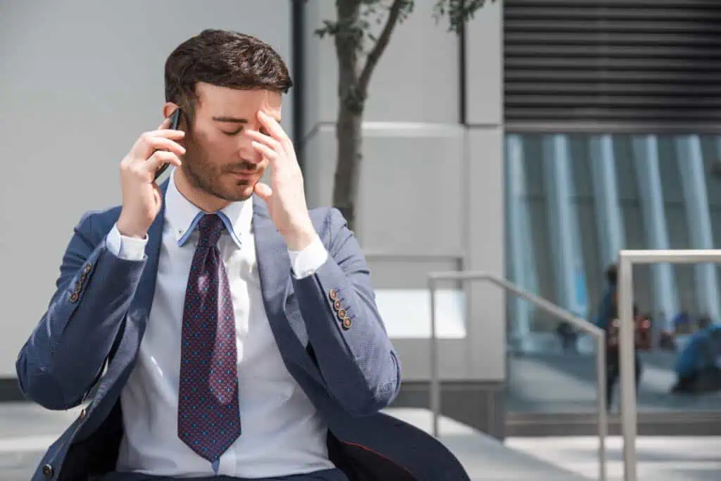 De telemarketing a cobrança: como lidar com ligações indesejadas de empresas 1 empresario cansado falando no smartphone