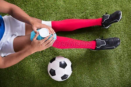 jogador de futebol lesionado aplicando bolsa 23859414 preview