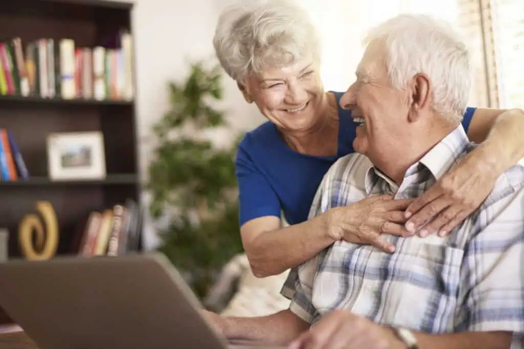 casamento de idosos usando laptop na sala de estar